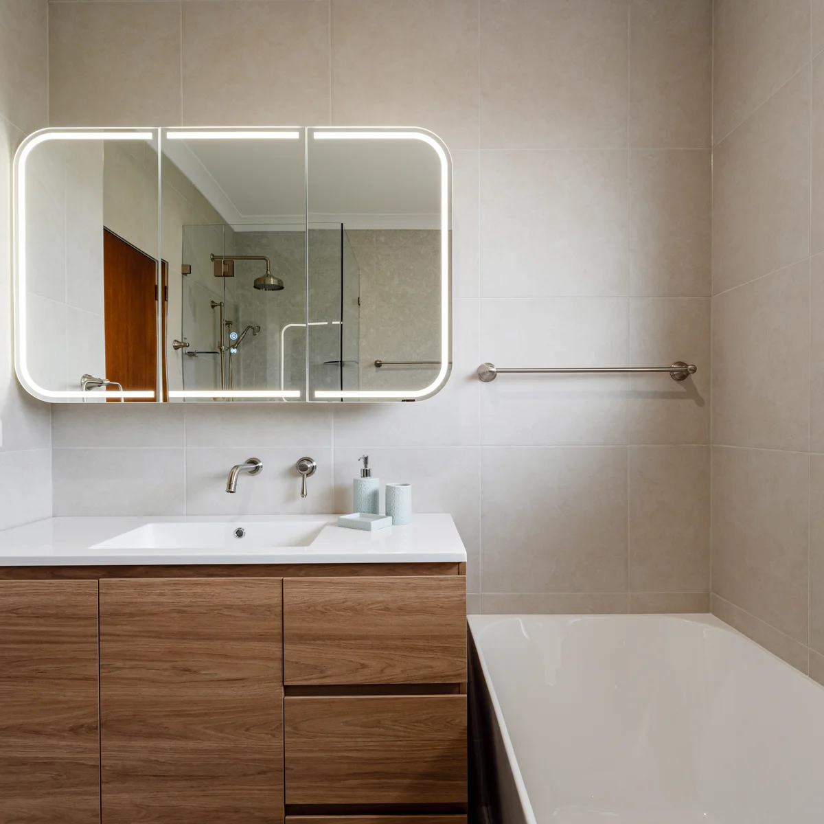 Contemporary bathroom with LED mirror and timber vanity unit