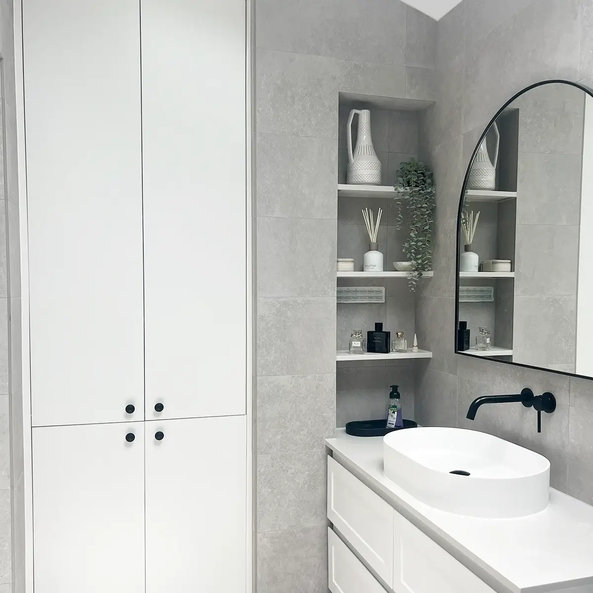 Modern ensuite with arched mirror, marble vanity and storage