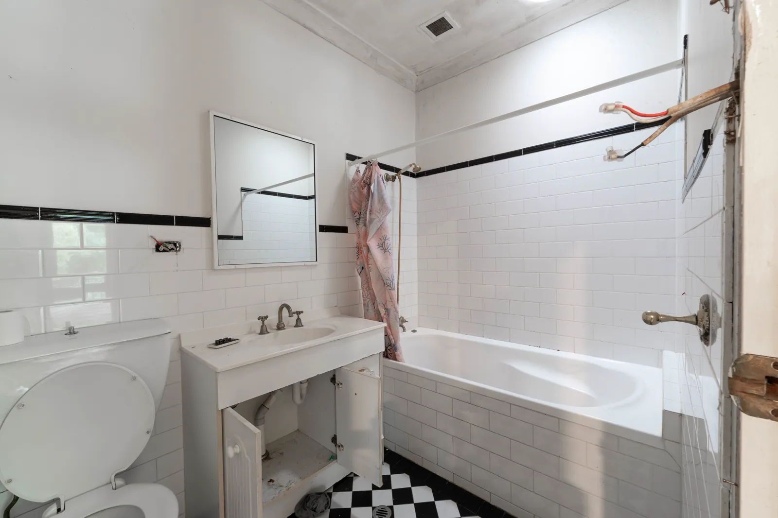 Original ensuite before renovation with dated fixtures and bathtub