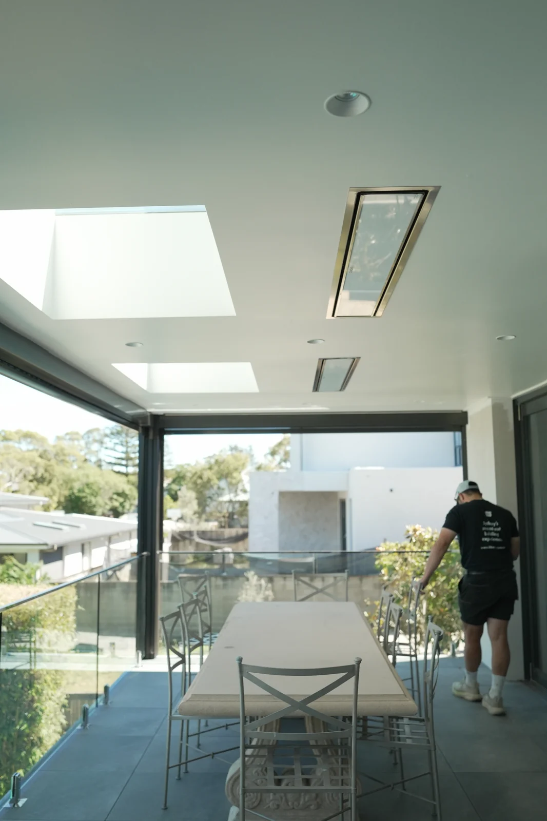 Level 1 entertaining area with frameless glass balustrade, outdoor furniture and recessed downlights