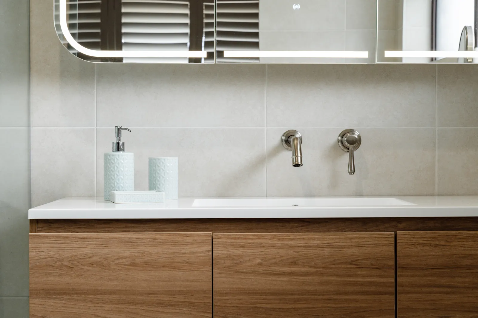 Custom timber vanity with white stone benchtop and wall-mounted brushed nickel tapware