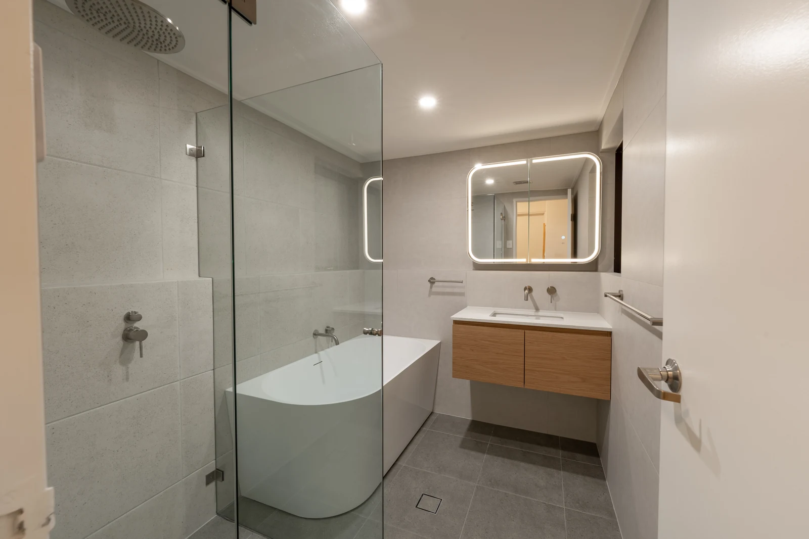 Renovated main bathroom in Wollstonecraft with freestanding bath, frameless shower screen and timber wall-hung vanity