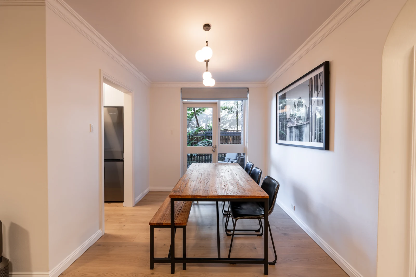Dining area of the renovated Wollstonecraft apartment, with oak flooring running through to the kitchen