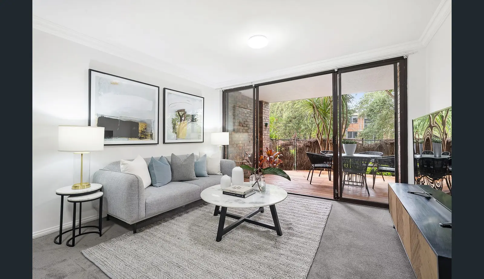 The living area at the Wollstonecraft apartment before renovation, opening to a covered balcony